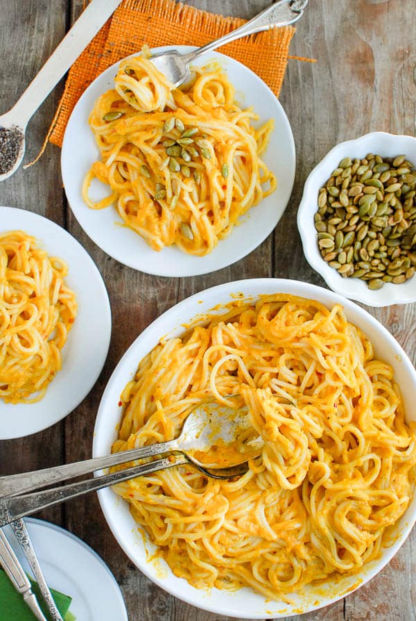 large bowl and servings of pumpkin chipotle cream sauce pasta 