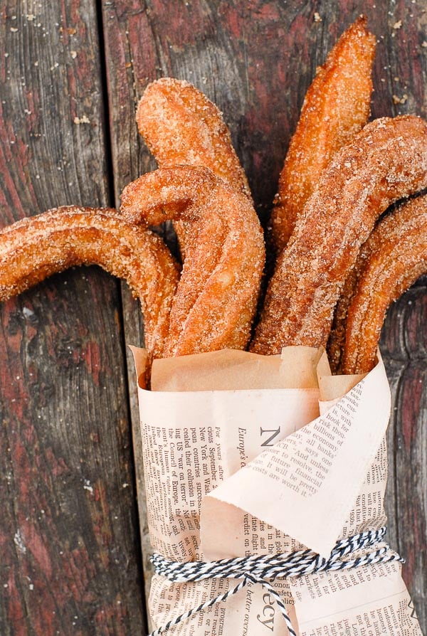 Churros with cinnamon sugar wrapped in newspaper