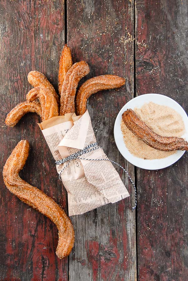 Churros wrapped in newspaper and in cinnamon sugar