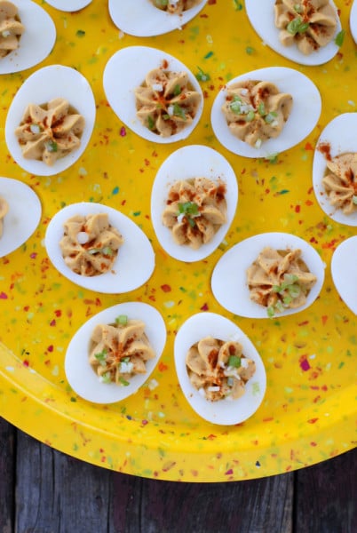 spicy deviled eggs on yellow egg plate