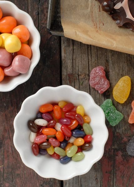 A plate of food sitting on top of a wooden cutting board, with Candy and Gourmet