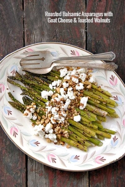 platter of Roasted Balsamic Asparagus with Goat Cheese and Toasted Walnuts on a weathered wood background