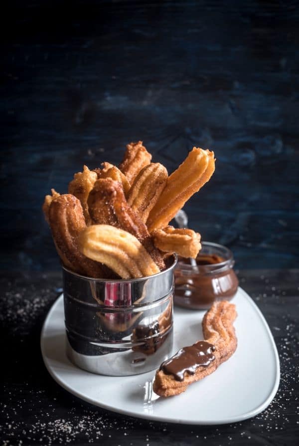 cooked churros with chocolate sauce