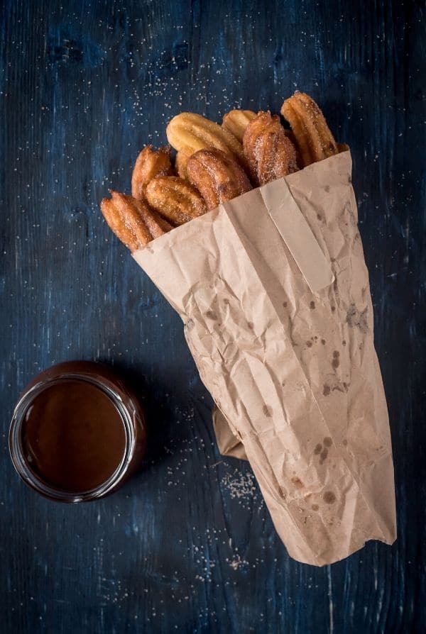 fried churros in a paper bag