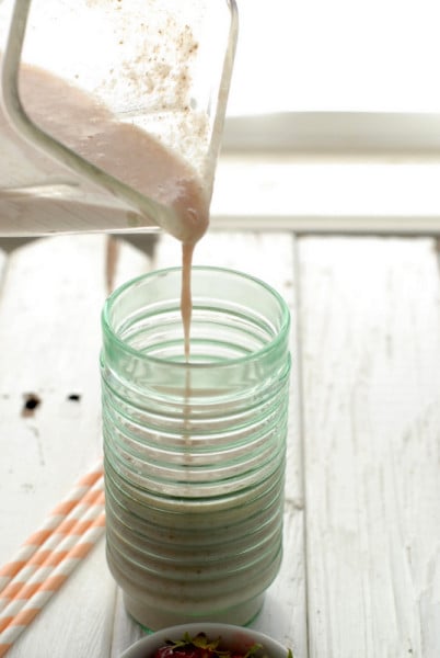 pouring almond smoothie into glass