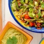 Taco Salad Ole in a colorful large bowl with Avocado Tequila Lime Dressing in a smaller orange bowl