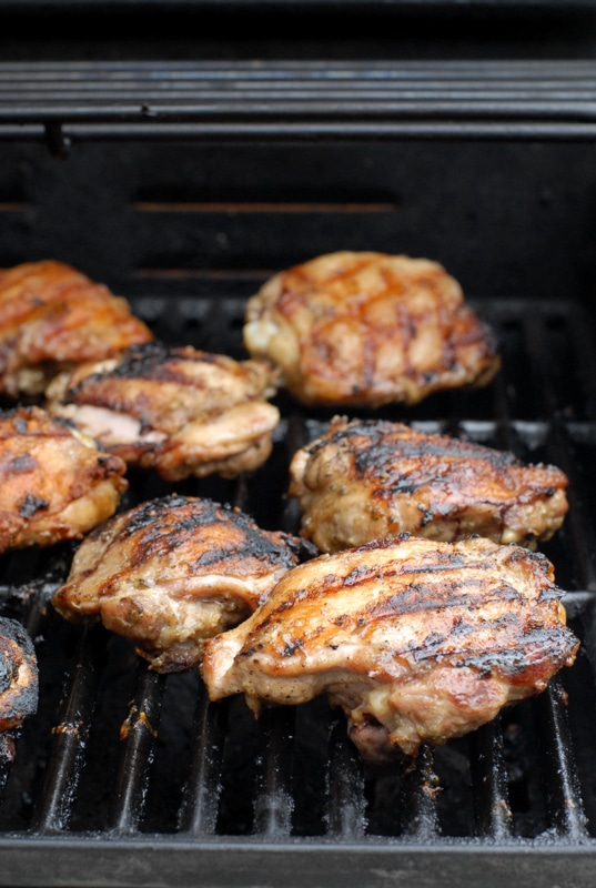Thai style grilled chicken thighs on grill
