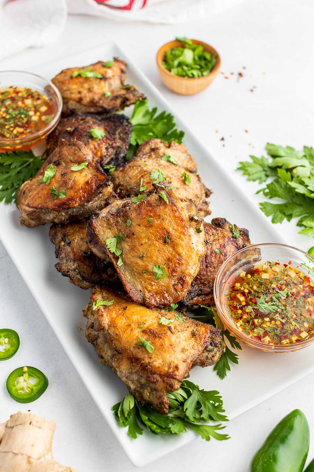 grilled chicken thighs with dipping sauce on platter 