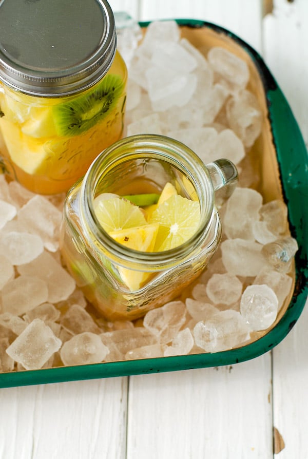 Chunks of pineapple and kiwi fruit in Mason jar mugs with Tropical Fruit Sangria 