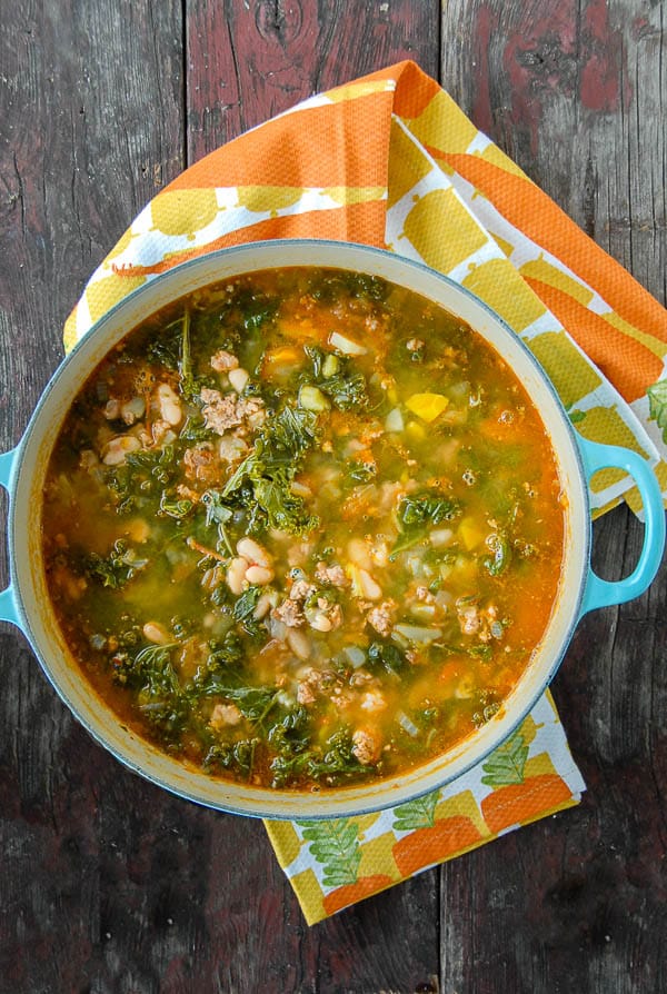 Peppery Sausage White Bean Kale Soup with kitchen towel