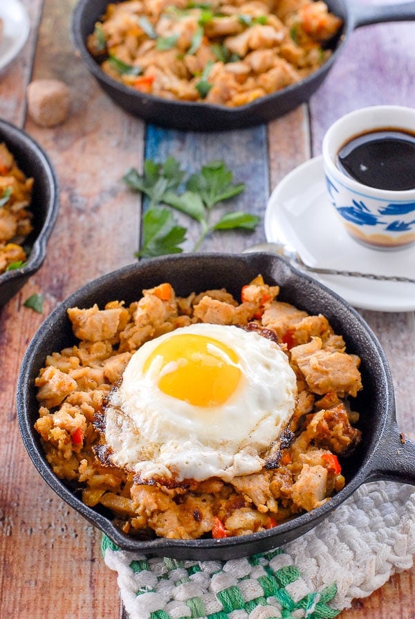 skillets of thanksgiving leftovers turkey hash with fried egg on top