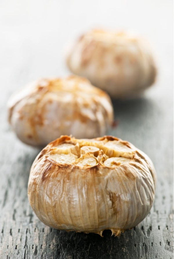 Roasted heads of garlic side view