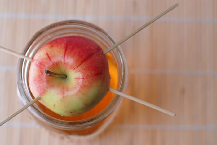 Homemade Apple Infused Vodka with apple on top of jar