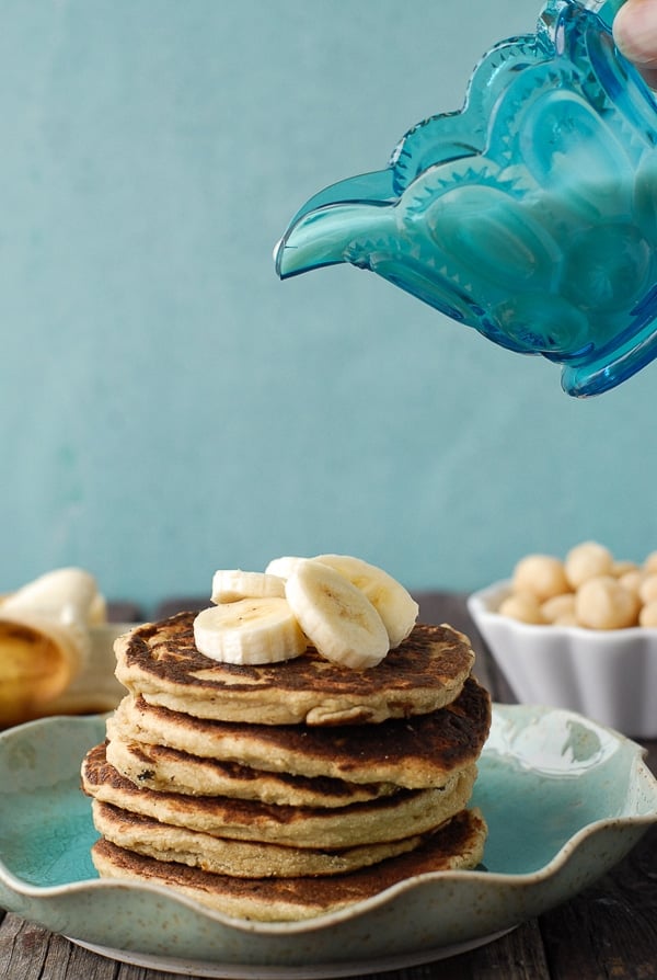 Banana-Macadamia Nut Pancakes with Coconut Syrup pouring