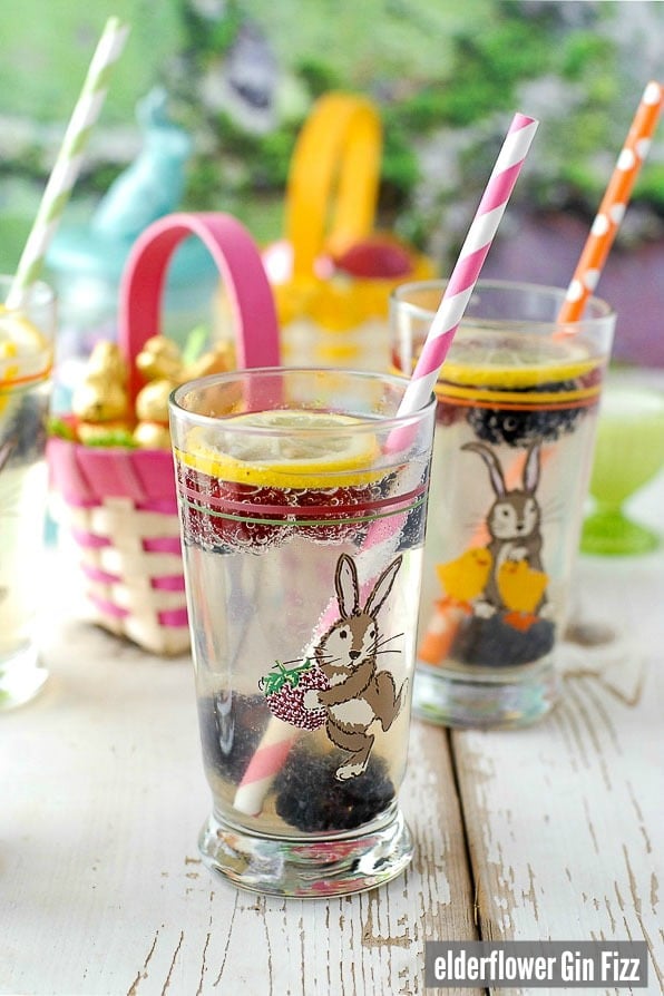 Elderflower Gin Fizz cocktails in easter glasses with colorful straws and frozen berries