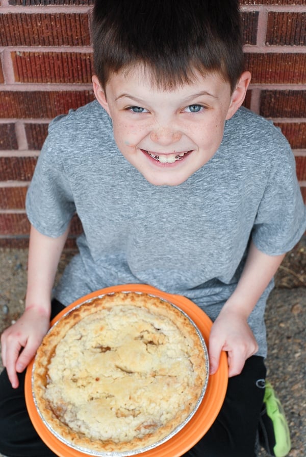 A little boy that is eating some pie