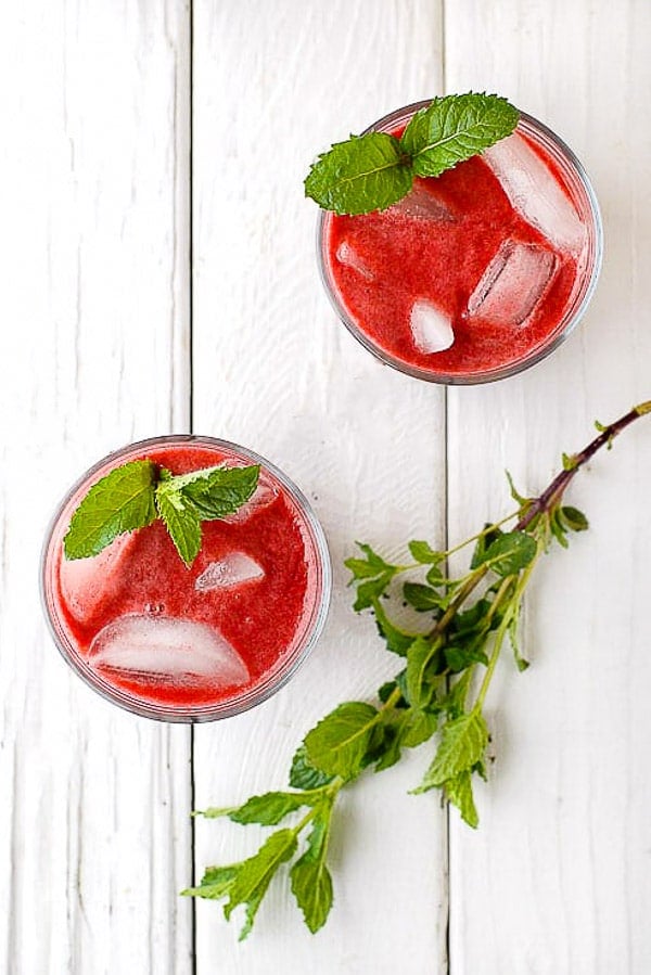 Two glasses of Blackberry Mint Agua Fresca with ice and fresh mint sprigs 