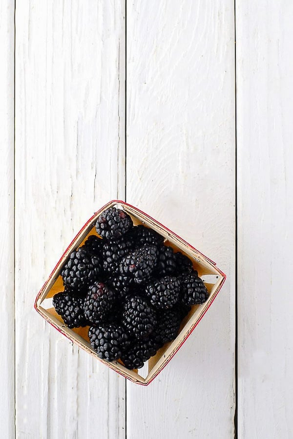 Freshly picked blackberries in a wooden berry carton