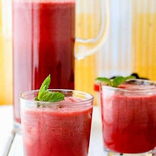 Fresh, light Blackberry Mint Agua Fresca with fresh mint sprigs on vintage white wood with yellow background