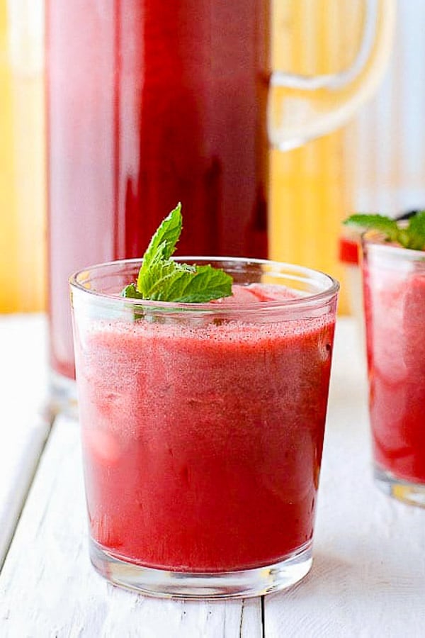 Fresh, fast to make Blackberry Mint Agua Fresca in a glass with fresh mint sprig and yellow metal background 