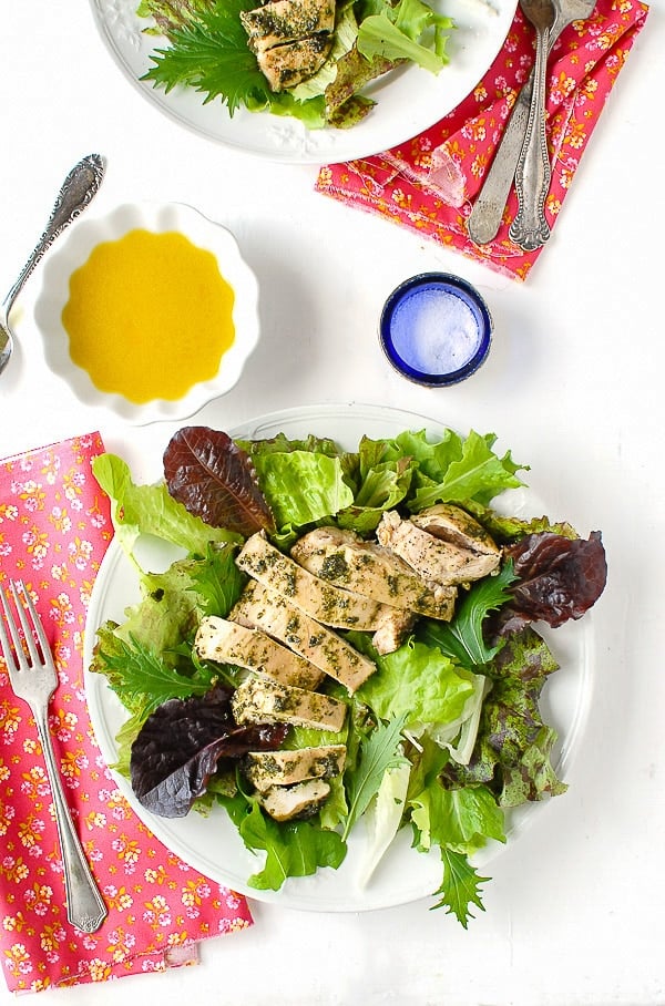 Juicy, fast to prepare boneless chicken breasts topped with tarragon walnut pesto on salad greens.