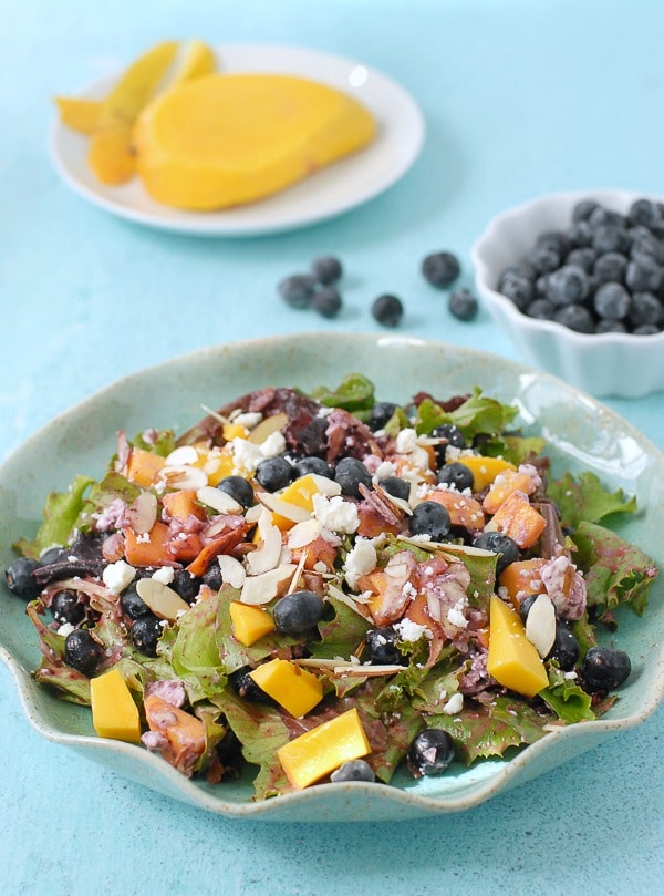 Blueberry-Mango Mixed Greens Salad with Blueberry-Guava Vinaigrette on blue plate
