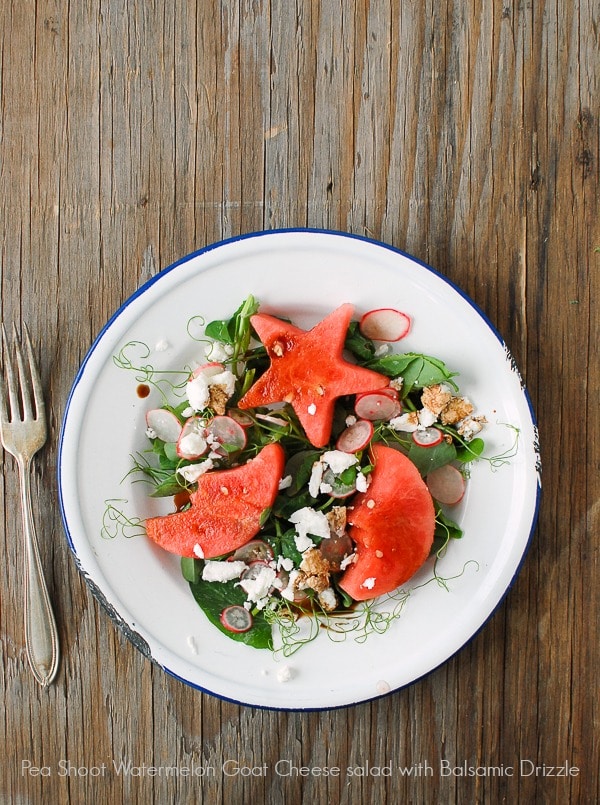 white plate with Pea Shoot Watermelon Goat Cheese Salad with Balsamic Drizzle