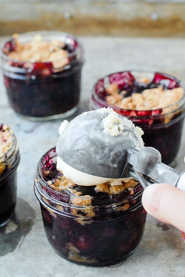Blueberry Mint Crumble in half pint Mason jars with vanilla ice cream scoop