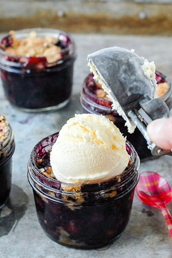 Easy gluten-free Blueberry Mint Crumble in Mason jars with vanilla ice cream on top