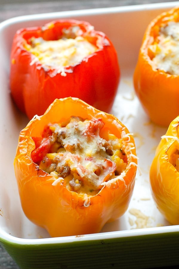 Fresh from the oven colorful gluten-free Sausage and Orzo Stuffed Sweet Peppers with melted cheese 