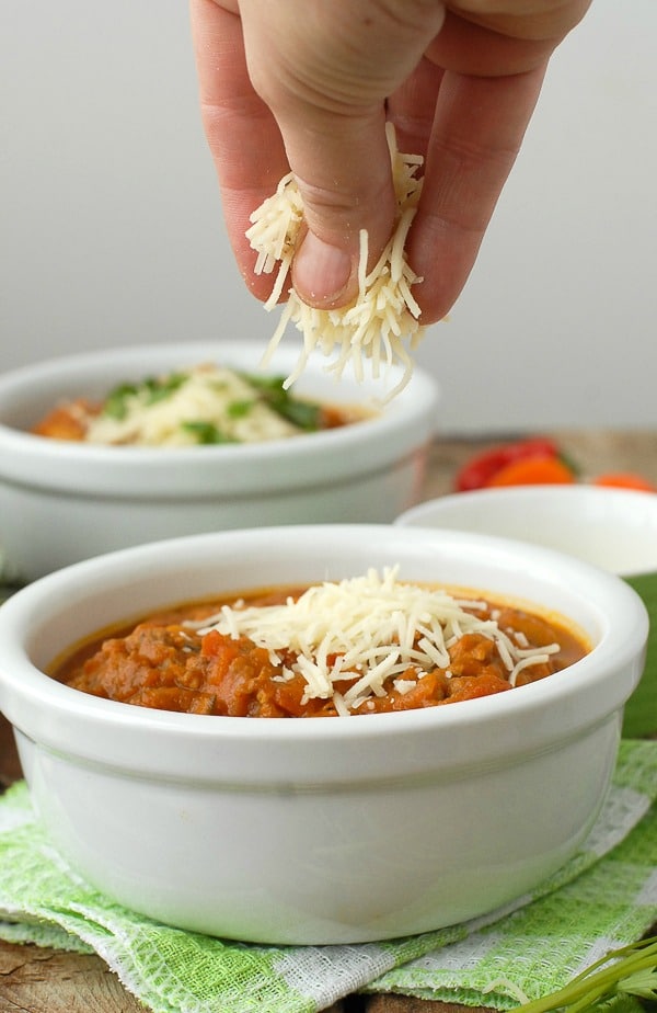 Gluten-free Pumpkin White Bean Sausage Chili with sprinkling cheese