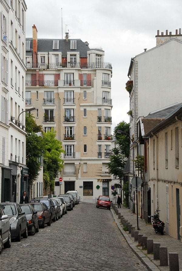 A street with cars parked on the side of a building in Montmartre Paris -