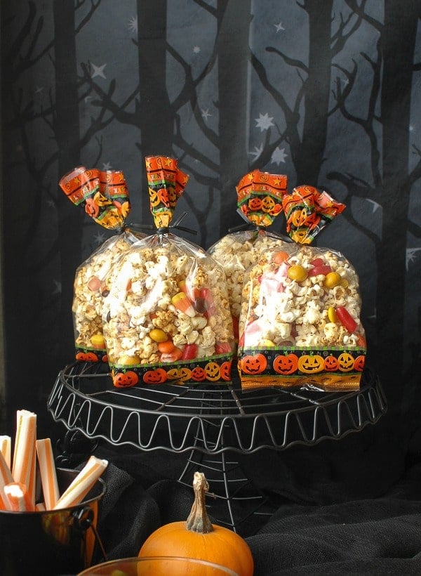 Orange-flavored Kettle Corn Halloween Treat Mix in bags on black stand