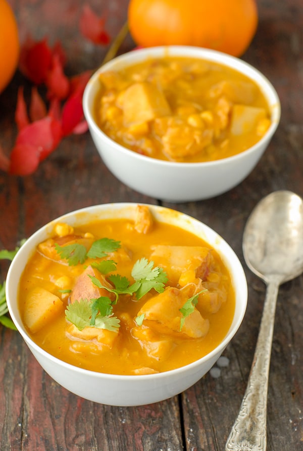 Bowls of slow cooker spicy pumpkin chicken corn chowder with cilantro garnish