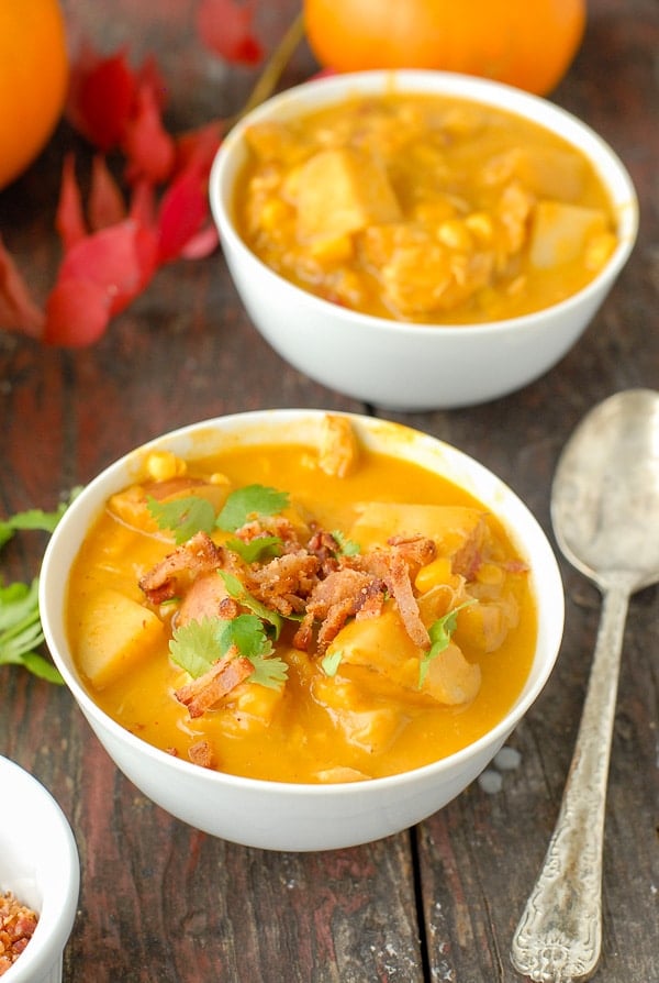 white bowls of slow cooker spicy pumpkin chicken corn chowder with bacon