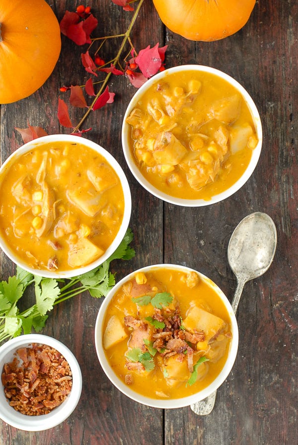 three white bowls of slow cooker spicy pumpkin corn chowder