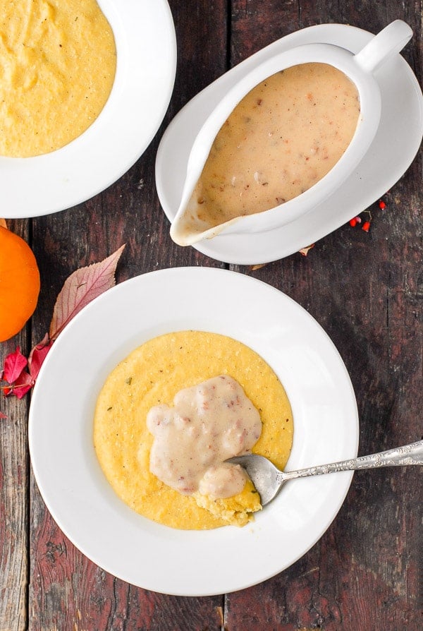 white bowl of pumpkin polenta with maple bacon gravy on top