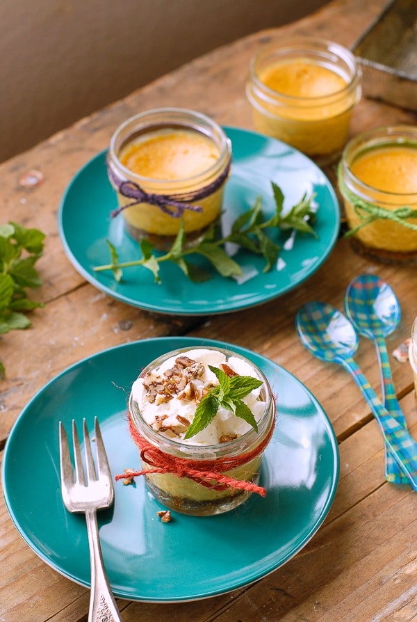 Mini Pumpkin Pie Cheesecakes in jars on teal plate