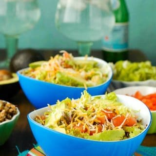 Lean Turkey Black Bean Quinoa Burrito Bowls topped with Mexican Cheese in blue bowls