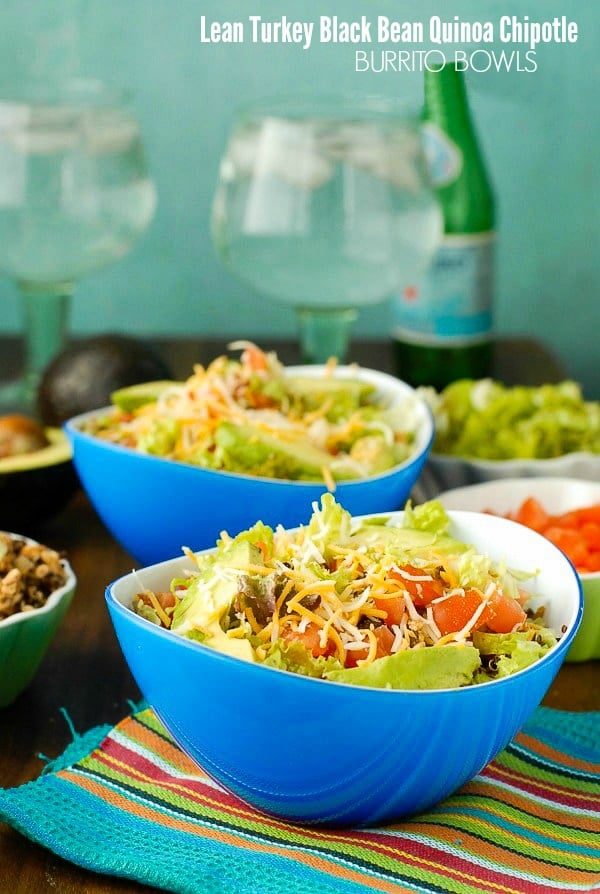 Lean Turkey Black Bean Quinoa Burrito Bowls topped with Mexican Cheese in blue bowls