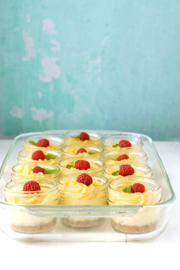 Clear baking pan filled with Mini Mascarpone Key Lime Curd Cheesecakes in Jars