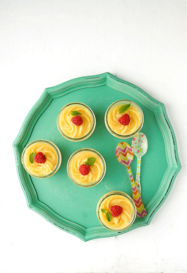 Mini Mascarpone Key Lime Curd Cheesecakes in Jars on a teal tray with colorful Sabre French spoons