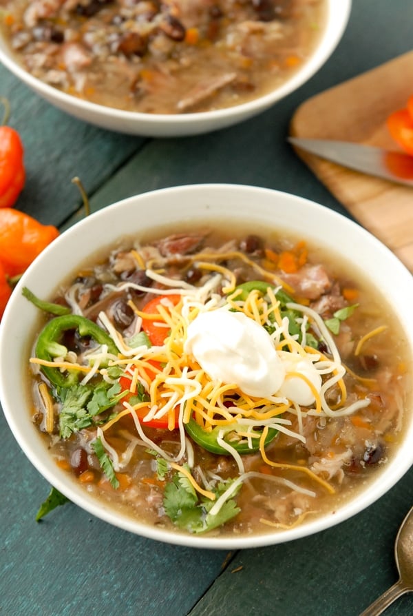  Fully loaded bowl of slow cooker black bean and hambone soup with cumin topped with grated cheddar