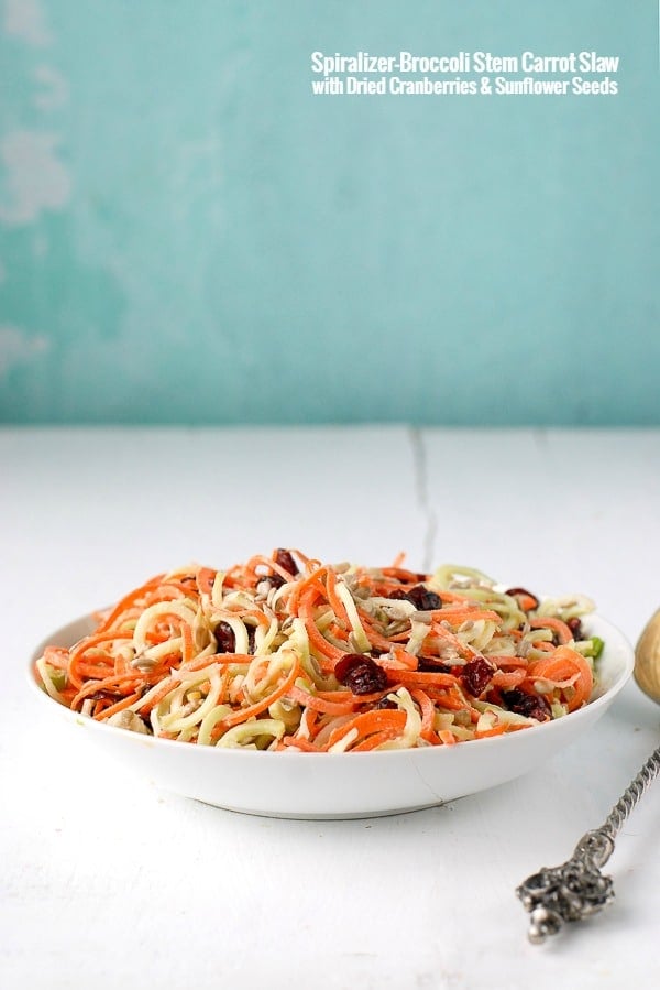 white bowl of Spiralized Broccoli Stem Carrot Slaw with Dried Cranberries and Sunflower Seeds