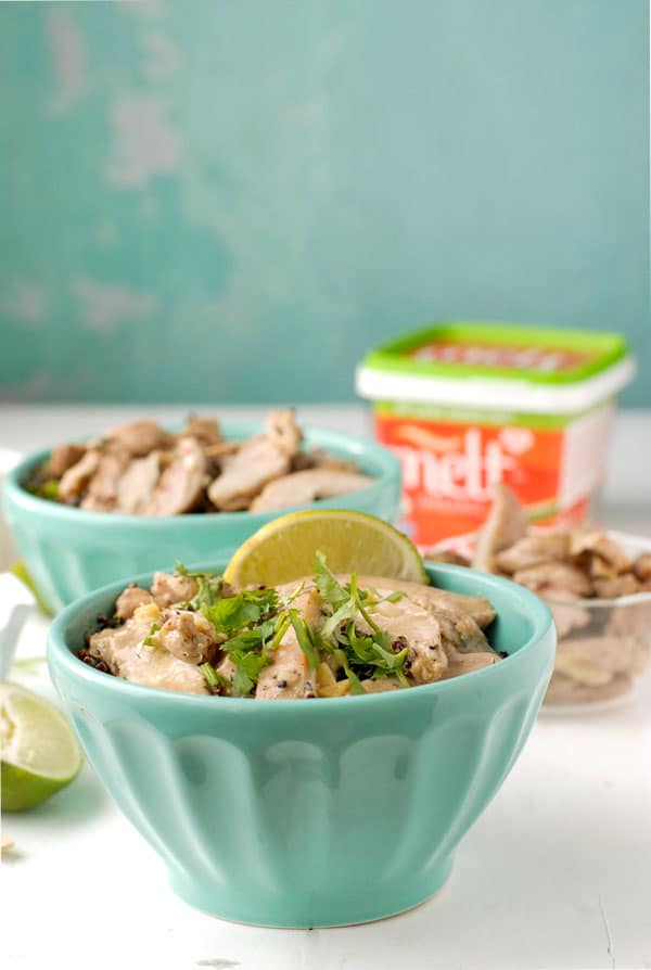 Two servings of Thai Chicken Thigh Basil Quinoa Bowl with sliced chicken thighs, lime wedges