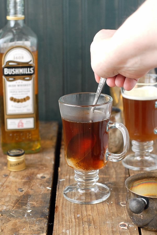 Authentic Irish Coffee recipe - stirring the sugar into the coffee in a glass mug