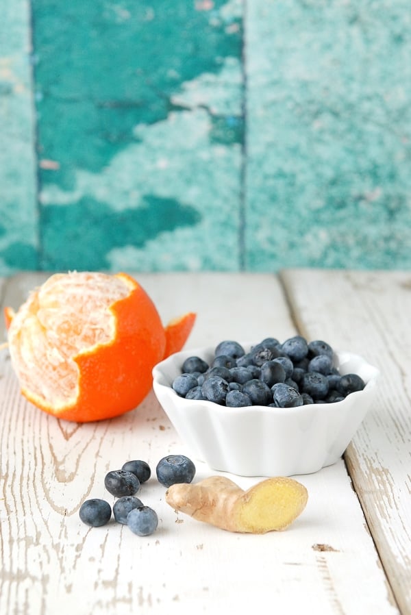 semi peeled orange and bowl of blueberries