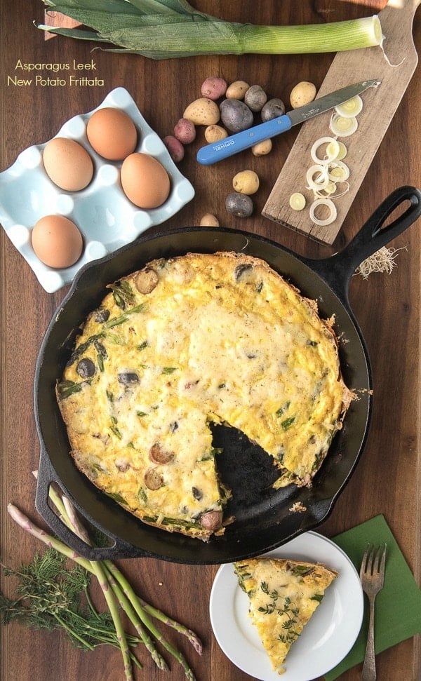 Simple and seasonal Asparagus Leek New Potato Frittata topped with melted Havarti Dill cheese in a cast iron skillet