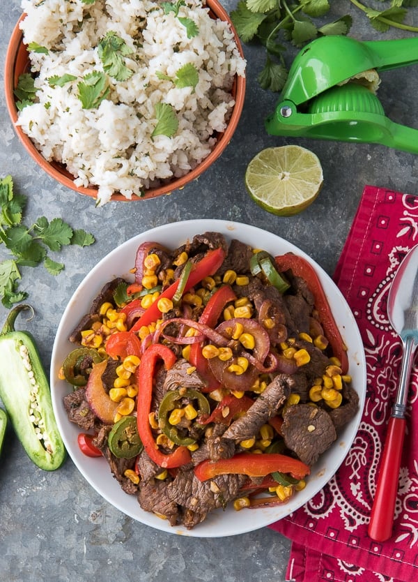 Bowl of Spicy Southwestern Steak Stir Fry with Cilantro-Lime Rice and lime slices