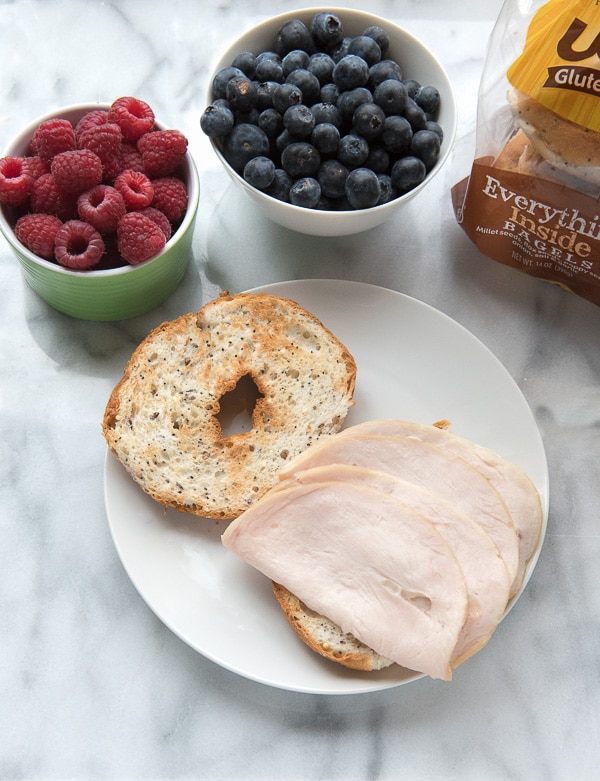 bagel with turkey and bowls of berries